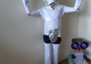 Chłopiec z stroju kosmicznym. Ma maskę na twarzy. Strój jest z papieru i folii metalowej